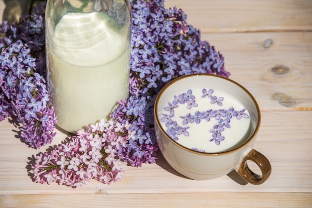 Beker met melk en kleine paarse lila bloemen