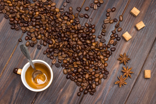 Beker met overgebleven koffie. Koffiebonen, steranijs en stukjes bruine suiker