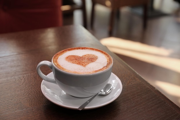 Beker met warme smakelijke koffie op houten tafel in café close-up weergave
