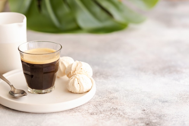 Beker op zwarte koffie met groene palmbladeren