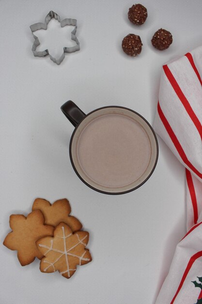 Foto beker warme chocolade in een kerstscène sneeuwvlokkenvormige koekjes chocolade en een keukentoilet