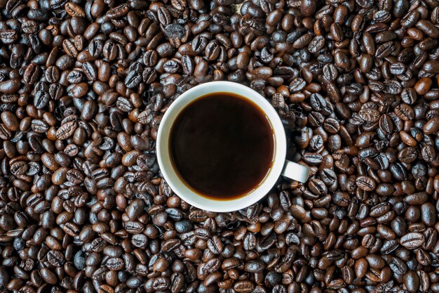 Beker warme koffie op een stapel koffiebonen