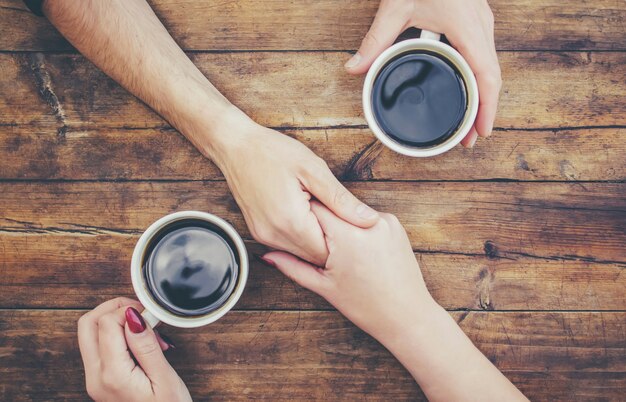 Bekers met een koffie in de handen van mannen en vrouwen. Selectieve aandacht.