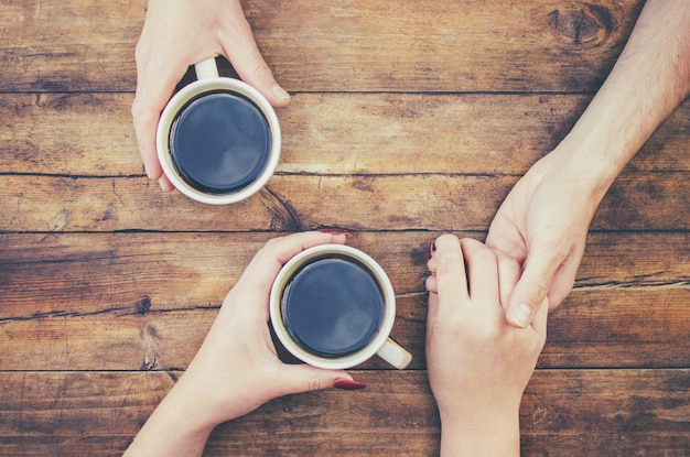 Bekers met een koffie in de handen van mannen en vrouwen. Selectieve aandacht.