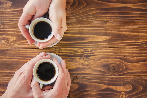 Bekers met een koffie in de handen van mannen en vrouwen.