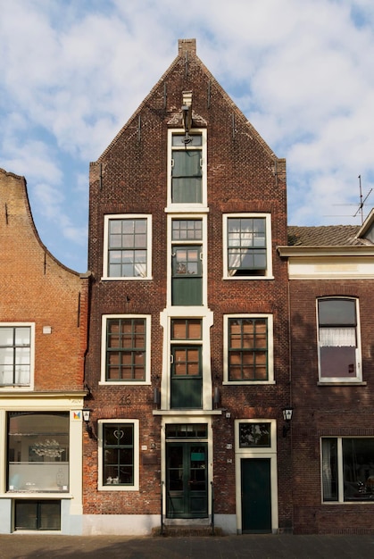 Bekijk een oud stenen huis met luiken voor de ramen van Nederland Holland