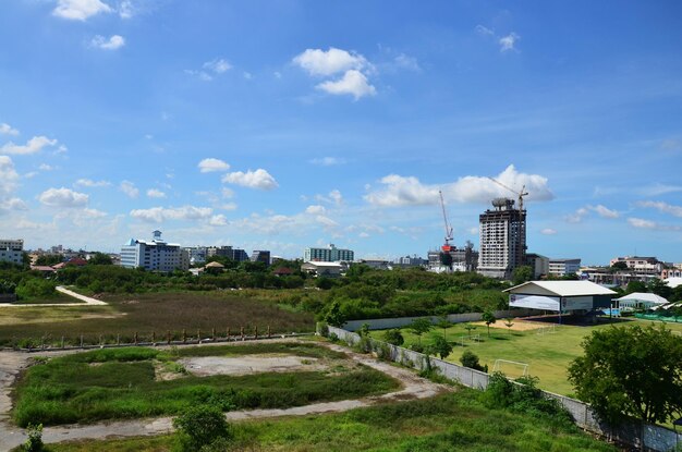 Bekijk landschap grasveld en stadsgezicht van bangkok stad met zware machines werken bouwer nieuwbouw toren kantoor betonnen structuur op bouwplaats op 5 juli 2014 in Bangkok Thailand