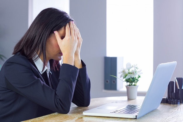 Beklemtoonde onderneemster die bij haar bureau werkt