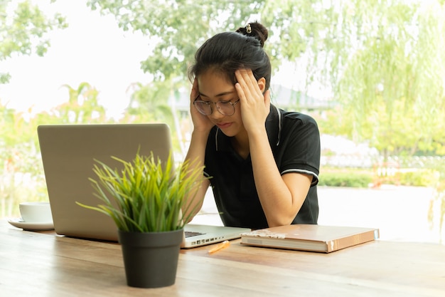 Beklemtoonde student die plotseling pijn voelt na lang het gebruiken van laptop voor studie.