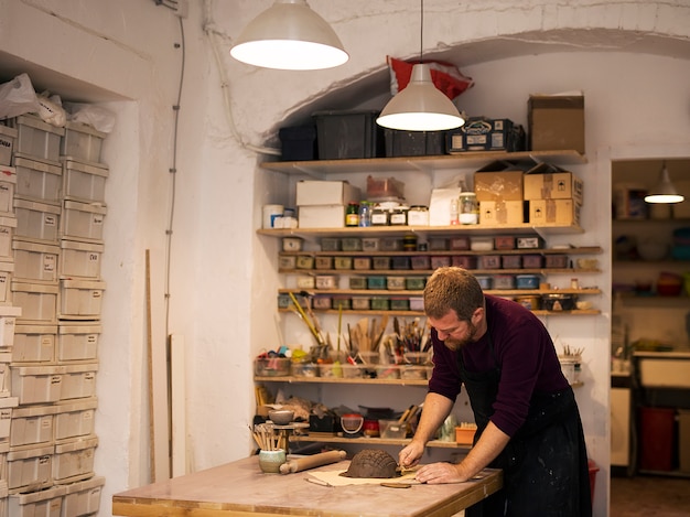 Bekwame meester die kleistukken voorbereidt voor zijn nieuwe creaties