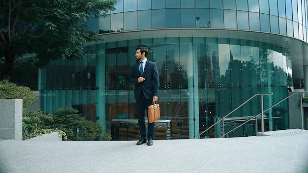 Bekwame zakenman in een formeel pak terwijl hij bij het Exultant-gebouw staat