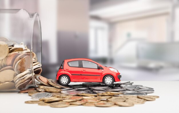 Belastingconcept auto. Stapel munten en speelgoedauto. geld besparen voor transport