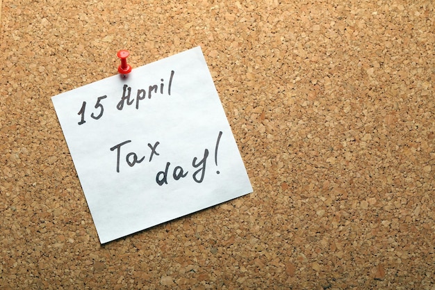 Belastingdag handgeschreven herinnering op 15 april vastgemaakt aan het bovenaanzicht van het bord