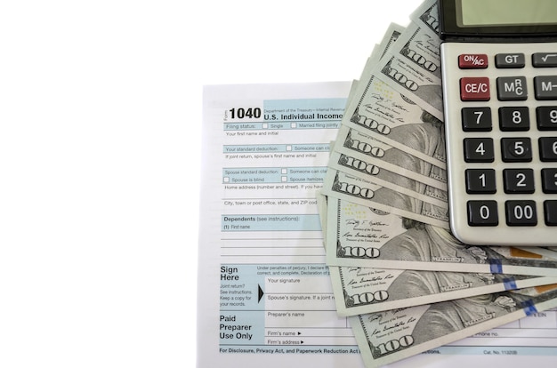 belastingformulieren 1040 met dollars en rekenmachine op witte achtergrond