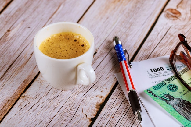 Belastingseizoen een kantoor met een bril en pen op aangifte inkomstenbelasting 1040 met zwarte koffie