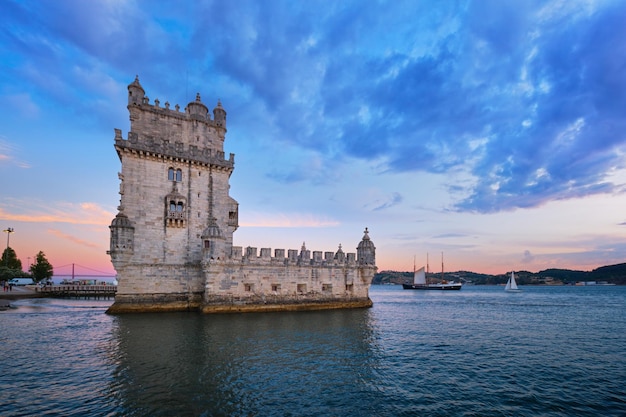 Photo belem tower on the bank of the tagus river in dusk after sunset lisbon portugal