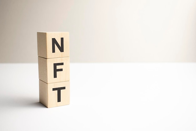 Belettering NFT op houten kubussen op een grijze achtergrond