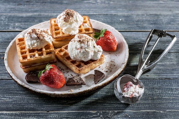 Belgian Wafers with vanilla ice cream, fresh strawberries and chocolate. Delicious breakfast.