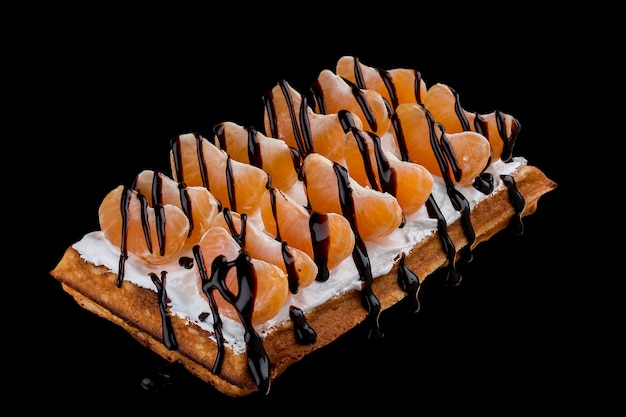 Belgian waffle with cream tangerine and chocolate On dark background