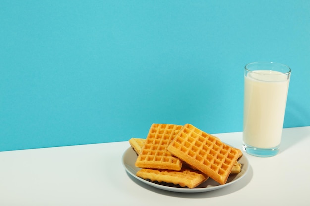 Belgian waffles on blue and white background Belgian waffles with honey and milk Freshly baked Belgian waffles