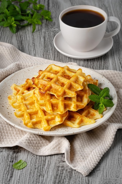 Belgian waffles and coffee on a gray background