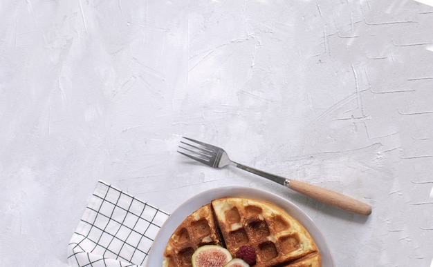 Waffle belgi, fichi, lamponi, miele, caffè espresso, fondo di legno bianco, fondo piatto