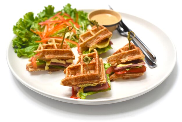 Belgian waffles on white plate with greens closeup