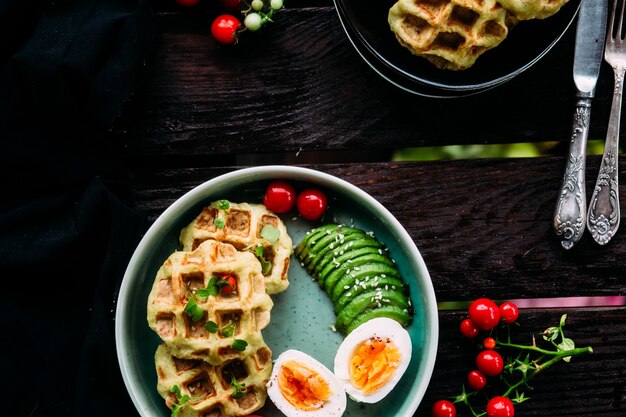 Belgian waffles with avocado egg and tomato Healthy breakfast