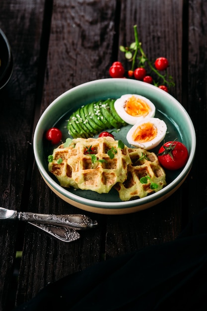 Belgian waffles with avocado egg and tomato Healthy breakfast