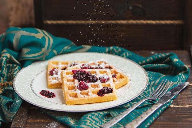 Belgian waffles with berries are poured with jam