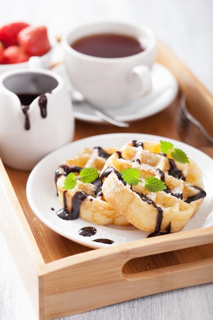 Belgian waffles with chocolate and powder sugar for breakfast