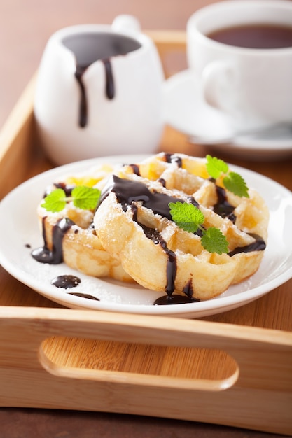 Belgian waffles with chocolate and powder sugar for breakfast