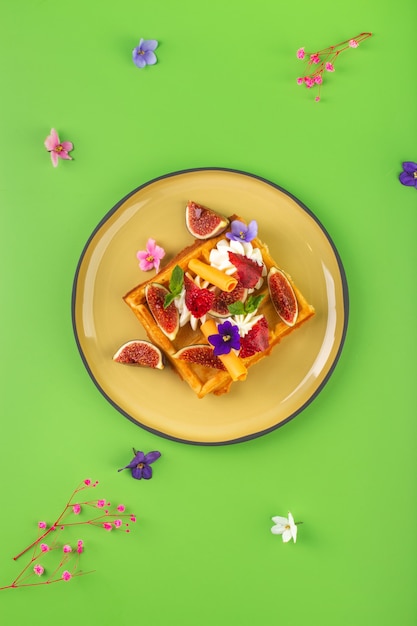 Belgian waffles with cream figs flowers and berries high quality photo