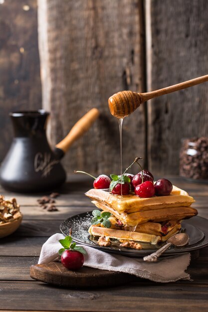 belgian waffles with honey and powdered sugar. Cherries. Coffee beans in glass. Turkish co