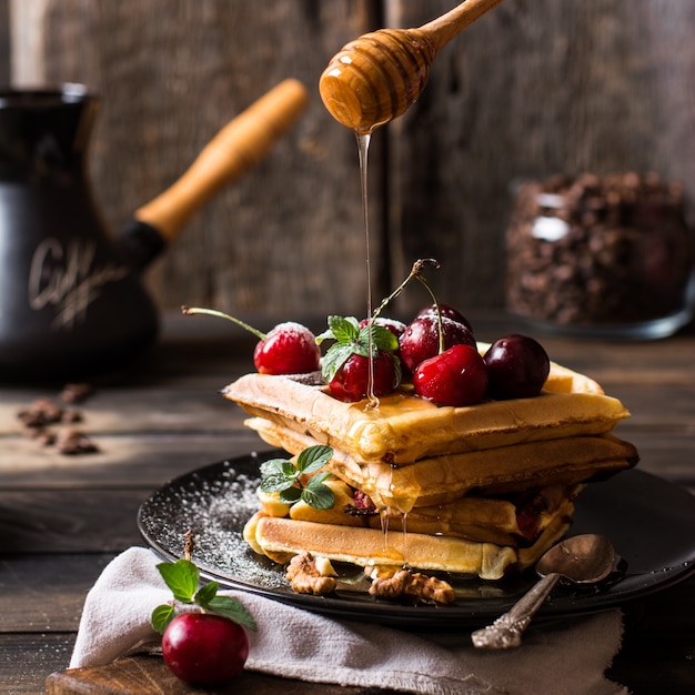 belgian waffles with honey, powdered sugar. Cherries. Coffee beans. Turkish coffee pot for