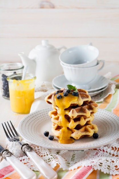 Belgian waffles with lemon kurd and blueberries. rustic style. selective focus