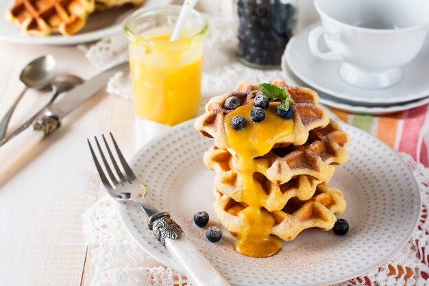 Belgian waffles with lemon Kurd and blueberries. Rustic style. Selective focus.