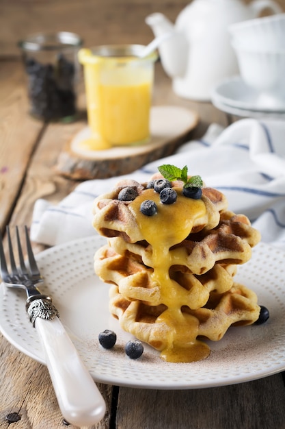 Belgian waffles with lemon Kurd and blueberries. Rustic style. Selective focus.