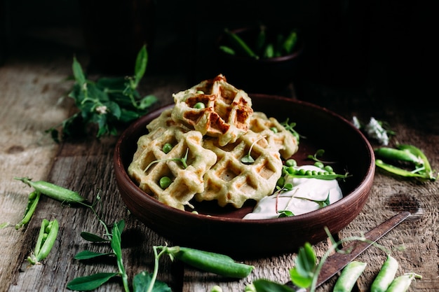 Belgian waffles with sauce and green peas