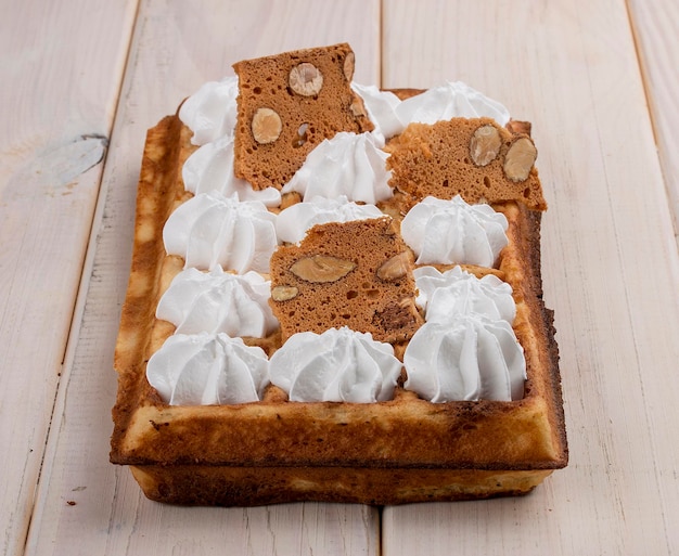 Belgische wafel meringue en amandelchips op een lichte houten ondergrond