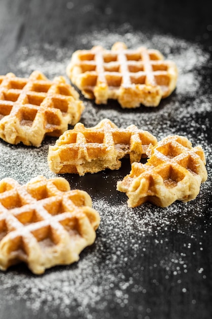 Belgische wafels bestrooid met suiker op zwarte tafel