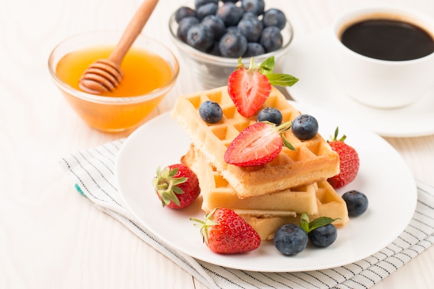 Belgische wafels met honing, aardbei, bosbes