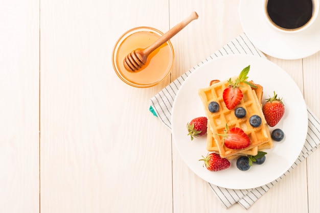 Belgische wafels met honing, bosbessen en aardbeien