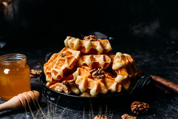 Belgische wafels met honing en noten op een donkere achtergrond