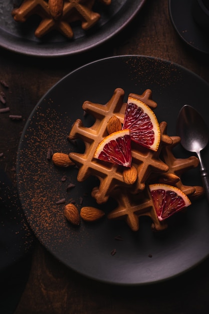 Belgische wafels met sinaasappel op een bord, plat gelegd