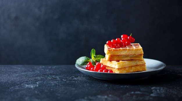 Belgische wafels met verse rode bessenbessen Donkere leisteenachtergrond Kopieer de ruimte