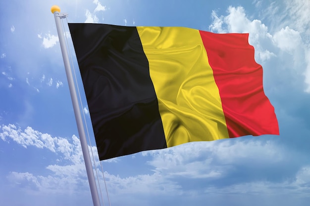 空の背景にベルギーの旗