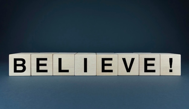 Photo believe the cubes form the word believe the concept of the word believe