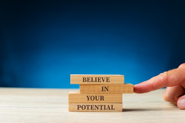 Believe in your potential sign written on wooden pegs