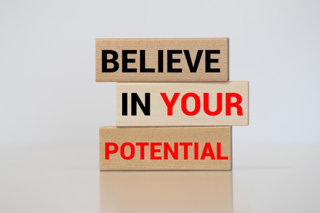 Photo believe in your potential word written on wooden blocks motivation for achievements in business or career concept